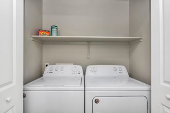 Two white front loading washing machines in a laundry room.